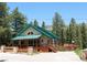 Welcoming two-story home with a spacious porch, green metal roof, wood accents, and scenic surroundings at 4178 Matterhorn Way, Las Vegas, NV 89124