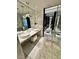 Marble-tiled bathroom with double sinks, pendant lighting, and a walk-in shower at 4381 W Flamingo Rd # 2022, Las Vegas, NV 89103