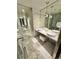 Marble-tiled bathroom with double sinks, pendant lighting, and a walk-in shower at 4381 W Flamingo Rd # 2022, Las Vegas, NV 89103
