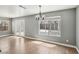 Bright living room featuring wood floors, a modern chandelier, and large windows at 4552 Aviation St, Las Vegas, NV 89115