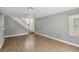 Open living space with wood flooring, neutral paint, a ceiling fan, and staircase access at 4552 Aviation St, Las Vegas, NV 89115