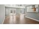 Open-concept living area with wood flooring, a ceiling fan, and a seamless connection to the outdoors at 4552 Aviation St, Las Vegas, NV 89115
