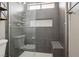 Updated tiled shower features glass doors, a built-in seat, and modern fixtures at 4552 Aviation St, Las Vegas, NV 89115