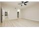 Spacious bedroom with wood-look floors, ceiling fan, and a glimpse into the connected bathroom at 4810 Grey Wolf Ln # 104, Las Vegas, NV 89149