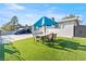 Backyard featuring a dining set with a blue umbrella on an artificial lawn at 5004 Cannon Blvd, Las Vegas, NV 89108