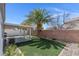 A serene backyard offers artificial turf, a covered patio, and a mature palm tree at 509 Regal Robin Way, North Las Vegas, NV 89084