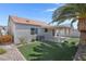 Enjoy a private backyard featuring artificial turf, a covered patio, and a mature palm tree at 509 Regal Robin Way, North Las Vegas, NV 89084