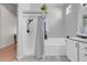 Bathroom featuring a shower with glass doors and a tiled bathtub combo with bright natural lighting at 509 Regal Robin Way, North Las Vegas, NV 89084