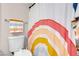 Bright bathroom featuring a colorful rainbow shower curtain and a neatly arranged towel at 509 Regal Robin Way, North Las Vegas, NV 89084