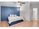 Comfortable bedroom featuring a blue accent wall, wood floors, and a cozy bed with plush pillows at 509 Regal Robin Way, North Las Vegas, NV 89084