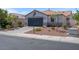 Charming single-story home with a desert landscaped front yard, a dark gray garage door, and a red tiled roof at 509 Regal Robin Way, North Las Vegas, NV 89084