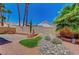 Lush backyard showcasing landscaping, including river rock, palms, and a turf accent at 5237 Crooked Sky Cir, Las Vegas, NV 89149