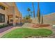 Well-maintained backyard featuring a manicured lawn, tall palm trees, and a brick-paved patio at 5237 Crooked Sky Cir, Las Vegas, NV 89149