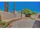 Fenced backyard featuring a brick patio, mature trees, and a gravel landscape at 5237 Crooked Sky Cir, Las Vegas, NV 89149