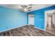 Bright blue bedroom features wood-look floors and a ceiling fan at 5237 Crooked Sky Cir, Las Vegas, NV 89149