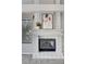 A close-up of the fireplace with white tiling, decor, and a large window showing an outside view at 5237 Crooked Sky Cir, Las Vegas, NV 89149