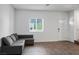 Bright living room featuring wood floors, a comfortable gray sofa, and plenty of natural light at 532 Clearsable Ave, Henderson, NV 89044