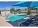 Community pool featuring lounge chairs, umbrellas, and well maintained landscaping at 532 Clearsable Ave, Henderson, NV 89044