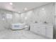 Luxurious bathroom showcasing a modern bathtub, dual sink vanity, and elegant marble tile at 5336 Regal Ave, Las Vegas, NV 89146