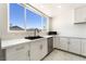 Bright kitchen with a large window, white cabinets, stainless steel appliances, and a modern faucet at 5336 Regal Ave, Las Vegas, NV 89146