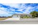 Expansive single-story home featuring a three-car garage, desert landscaping, and a long driveway at 5500 Santovito St, Pahrump, NV 89061