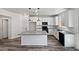 Modern kitchen with white cabinets, an island with countertop, and sleek black appliances at 5709 Jaysin Douglas St, North Las Vegas, NV 89031