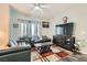 Inviting living room featuring hardwood floors, plush sofas, TV set, ceiling fan, and natural light at 6321 Rolling Rose St # 201, North Las Vegas, NV 89081