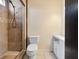 Bright bathroom featuring tiled shower with glass door, toilet, and white storage cabinet at 6436 Vinecrest Ave, Las Vegas, NV 89108