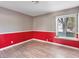 Bedroom featuring laminate flooring, a red accent wall, and a window at 6436 Vinecrest Ave, Las Vegas, NV 89108