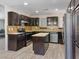 Well-lit kitchen featuring dark cabinetry, stainless steel appliances, and a convenient center island at 6436 Vinecrest Ave, Las Vegas, NV 89108
