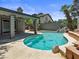 Backyard oasis featuring a sparkling pool, rock waterfall, covered patio, and ample deck space at 6436 Vinecrest Ave, Las Vegas, NV 89108