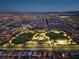 Night aerial view of community showcasing neighborhood parks, street lights, and distant mountain views at 6507 Creekside Cellars Ct, Las Vegas, NV 89139