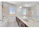 Bright bathroom showcasing a double sink vanity, a large mirror, and tub shower combination at 6507 Creekside Cellars Ct, Las Vegas, NV 89139