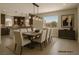 Elegant dining room with modern lighting, a large window, and comfortable seating at 6507 Creekside Cellars Ct, Las Vegas, NV 89139
