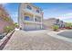 Two-story home with a long brick driveway and a three-car garage at 6507 Creekside Cellars Ct, Las Vegas, NV 89139