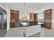 Open kitchen with granite countertops, large island, stainless appliances and dark wood cabinetry at 6507 Creekside Cellars Ct, Las Vegas, NV 89139