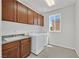 Bright laundry room featuring washer, dryer, granite countertop, sink and a window for natural light at 6507 Creekside Cellars Ct, Las Vegas, NV 89139