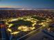 Aerial night view of the park with lights and the city skyline in the background at 6507 Creekside Cellars Ct, Las Vegas, NV 89139
