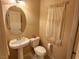 Cozy powder room featuring a pedestal sink, toilet, and a window with decorative curtains at 6729 Flamenco Ct, Las Vegas, NV 89139