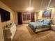 Spacious primary bedroom boasts soft lighting, a large window, and TV, creating a relaxing retreat at 6729 Flamenco Ct, Las Vegas, NV 89139