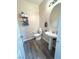 Half bathroom with modern vanity, laminate floors, and natural light at 6812 Dipper Ave, North Las Vegas, NV 89084