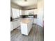 Bright kitchen with white cabinets, butcher block island, stainless steel appliances and vinyl flooring at 6812 Dipper Ave, North Las Vegas, NV 89084