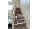 Carpeted stairs with white banister and a safety gate at 6812 Dipper Ave, North Las Vegas, NV 89084