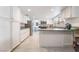 Spacious white kitchen with stainless steel appliances, an eat-in breakfast bar, and ample counter space at 7009 Rawlins Ct, Las Vegas, NV 89128