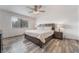 Bright main bedroom featuring hardwood floors, a ceiling fan, and two large windows at 7009 Rawlins Ct, Las Vegas, NV 89128