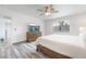 Bright main bedroom featuring hardwood floors, a ceiling fan, and a large window at 7009 Rawlins Ct, Las Vegas, NV 89128