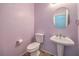 Cozy half bathroom featuring a pedestal sink and round mirror at 7427 Page Ranch Ct, Las Vegas, NV 89131