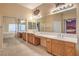 Bright bathroom featuring double sinks, a large mirror, a bathtub, and decorative wall art at 7427 Page Ranch Ct, Las Vegas, NV 89131