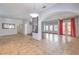 Bright open-concept living room featuring tile flooring, arched doorways, and large windows with stylish red curtains at 7427 Page Ranch Ct, Las Vegas, NV 89131