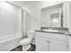 Bright bathroom featuring a shower-tub combination, wood-style flooring, and granite-style countertop at 7977 Whisper Words Ave, Las Vegas, NV 89113